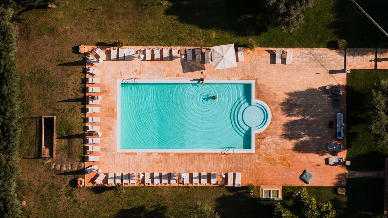 creative-approach-img Stunning aerial view of a resort swimming pool with sunloungers in Puglia, Italy.
